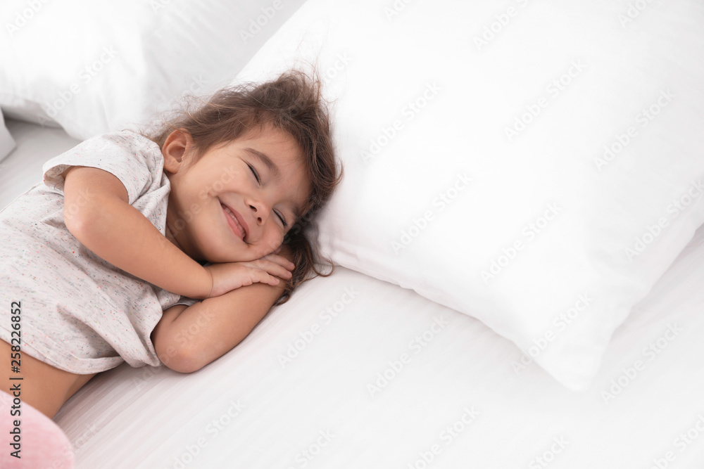 Cute little girl sleeping on bed. Space for text