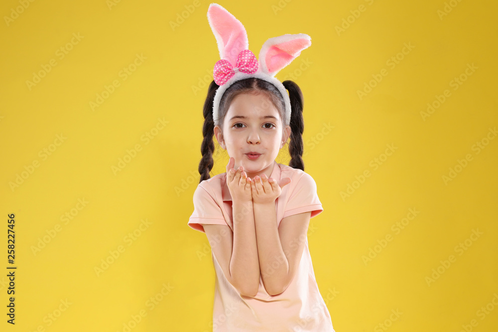 Portrait of little girl in Easter bunny ears headband on color background Portrait of little girl in Easter bunny ears headband on color background