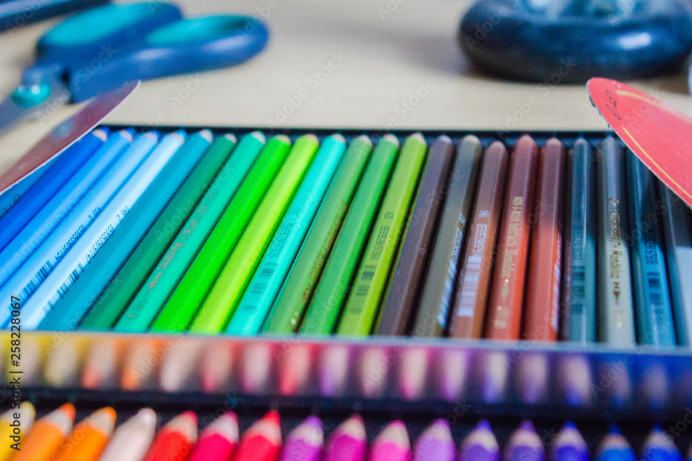 Fototapeta Colored pencils laid out in a tin box, a corner photo, focus on a few pencils.
