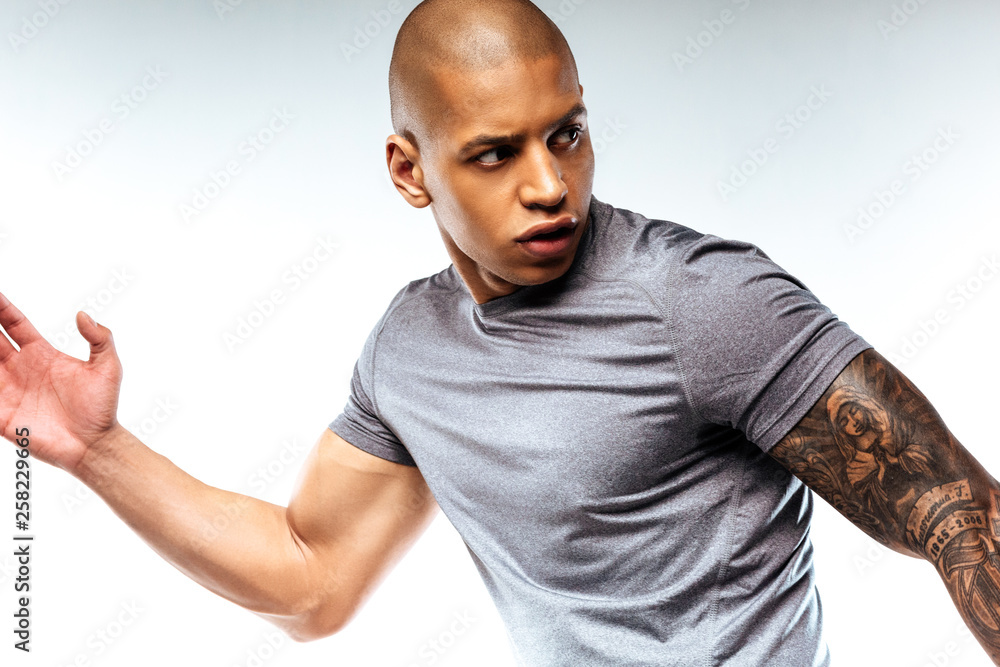 Concentrated bold muscular man doing sport exersises Concentrated bold muscular man doing sport exersises
