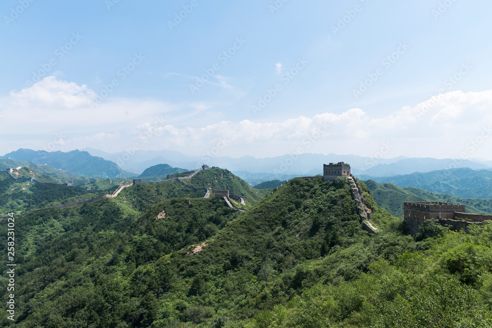 Panorama of Mutianyu, a section of the Great Wall of China. Mountains and hill ranges surrounded by green trees during summer. Huairou District, Beijing, China Panorama of Mutianyu, a section of the Great Wall of China. Mountains and hill ranges surrounded by green trees during summer. Huairou District, Beijing, China