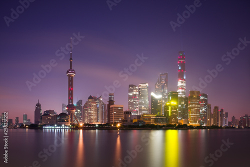 Long exposure of Pudong district, modern skyscrapers and Huangpu river in Shanghai at night. Cityscape and urban architecture in China