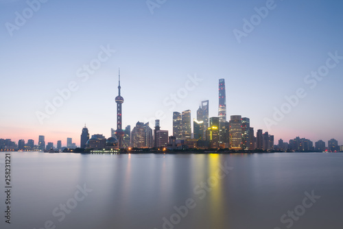Long exposure of Pudong district  modern skyscrapers and Huangpu river in Shanghai at sunrise. Urban architecture in China