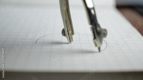 Macro of the compass drawing a circle on paper. Close up