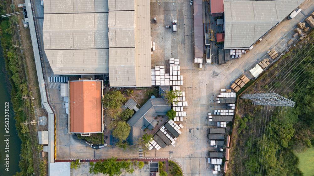 Warehouse logistic activity in Factory with forklift transport from drone aerial view.