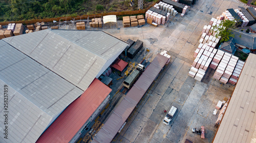 Warehouse logistic activity in Factory with forklift transport from drone aerial view.