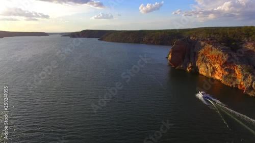 Boat sailing in the river on sunset time - record by drone