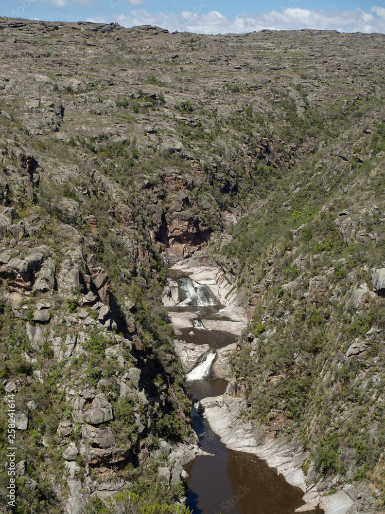 View of the Yuspe river running through the mountains at Cerro Blanco reserve, near Tanti and Los Gigantes, Cordoba, Argentina View of the Yuspe river running through the mountains at Cerro Blanco reserve, near Tanti and Los Gigantes, Cordoba, Argentina