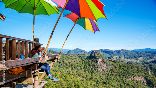 The girl sitting eating noodle in the rural village hanging legs style for viewpoint on the mountain,The local attractions of Mae Hong Son province Thailand.