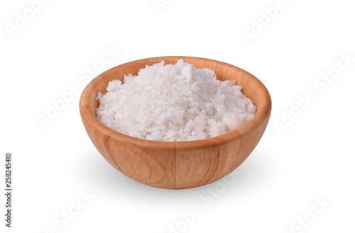 salt in a wooden bowl on white background.