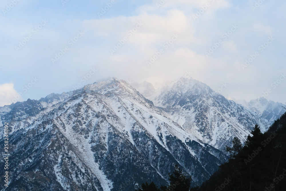 Mountain range of Caucasian Mountains in the cloud sky. Syltran gorge