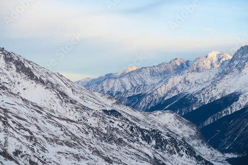 Mountain range of Caucasian Mountains in the clouds blue sky