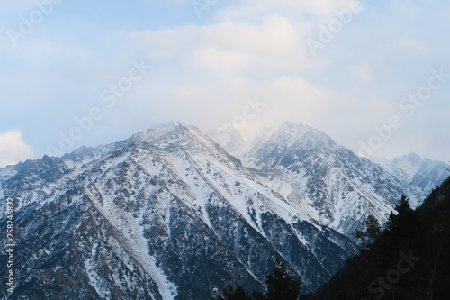 Mountain range of Caucasian Mountains in the cloud sky. Syltran gorge