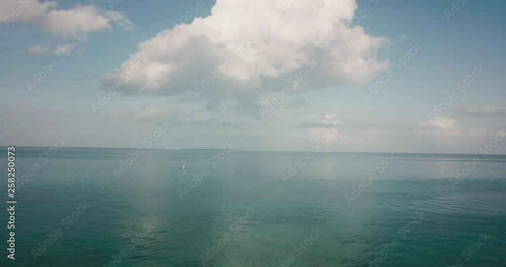 A huge cloud over a blue sea as a boat passes by A huge cloud over a blue sea as a boat passes by