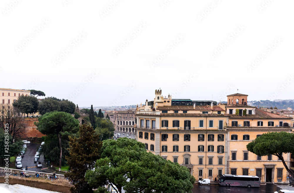 view of Rome with hill on cloudy day, buildings, pine trees,