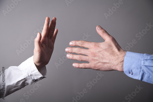 Female hand refusing male hand to shake. photo