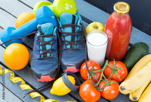 Fototapeta Naklejka Na Ścianę i Meble -  sneakers ,oranges, tomatoes, Apple, pear ,lemon, sports bracelet, bananas, milk, tomato juice , fruits and vegetables