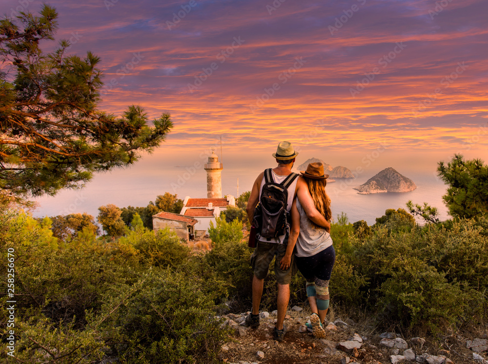 Young couple at looking at the scene at Cape Gelidonya Lighthouse during sunset