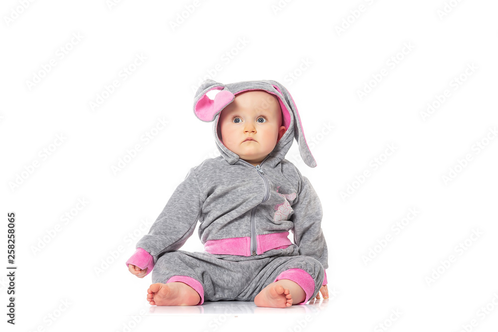 Cute little baby in bunny costume sitting on white background. children's games. baby emotions Cute little baby in bunny costume sitting on white background. children's games. baby emotions