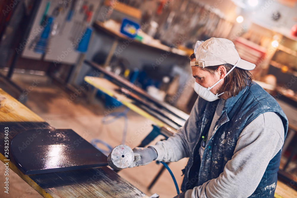 Male carpenter working on old wood in a retro vintage workshop. Male carpenter working on old wood in a retro vintage workshop.