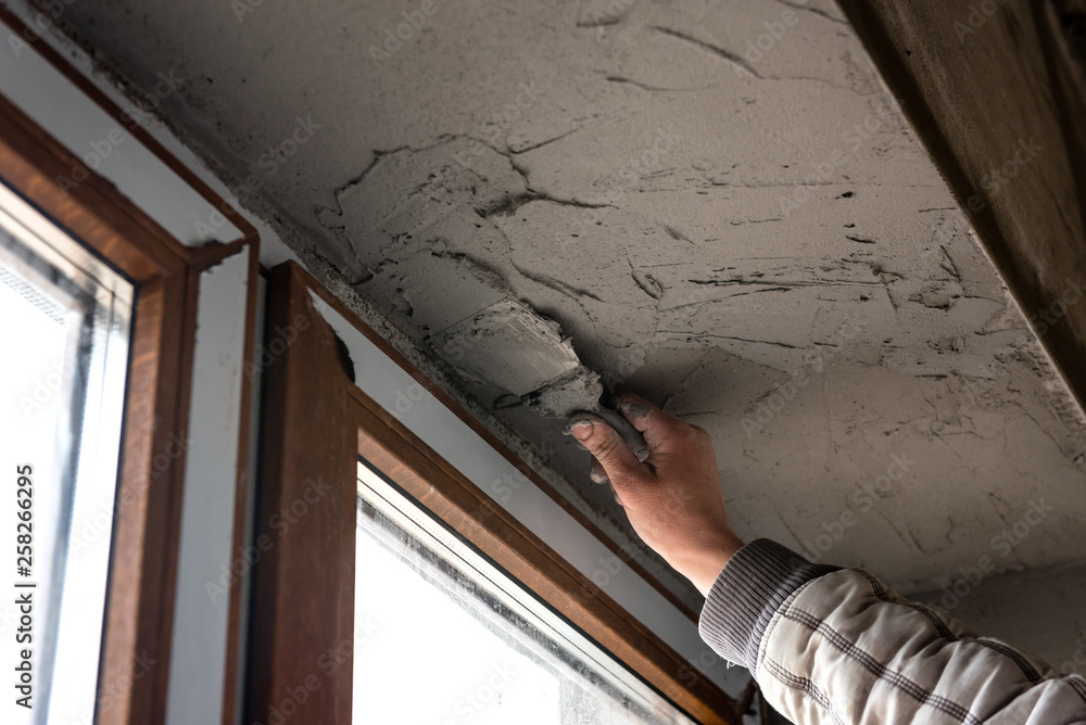 Obraz premium Preparing walls for wallpaper. Repair in the slopes of the window. The process of applying a layer of plaster on the sides of the window. 