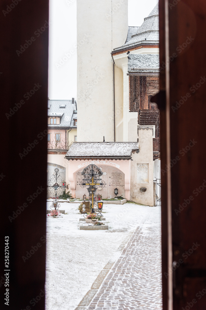 Fototapeta premium Winter. Exterior of the ancient Collegiate Church of San Candido. Snow atmosphere