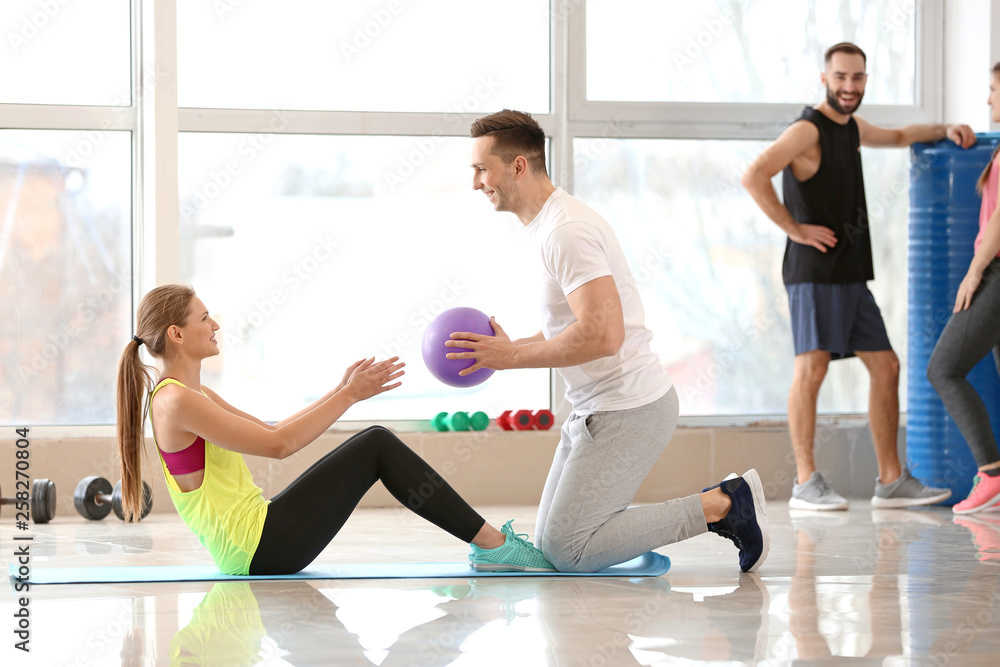 Fototapeta premium Sporty young people training in gym
