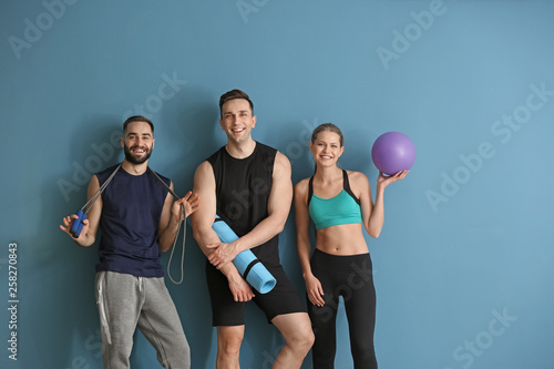 Sporty young people on color background