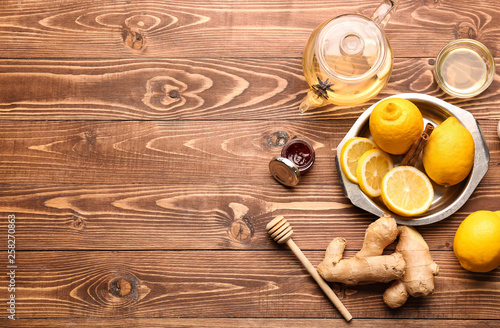Tasty tea with lemon, ginger and honey on wooden table