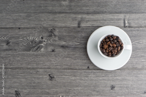 Coffee cup and coffee beans on wooden background. Top view and selective focus