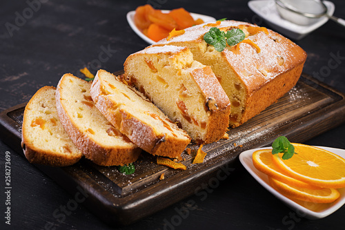 Fotografía Orange cake with dried apricots and powdered sugar.