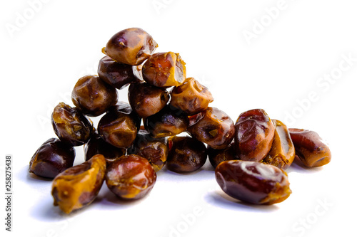 sweet dry dates folded down and laid out on a white background