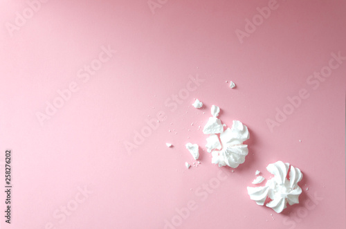 Crumbled meringue on the pink background, top view. Empty space for your design photo