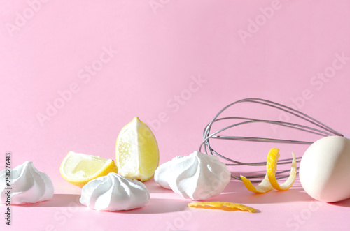 Lemon and egg as an ingredients for cooking delicious meringues on the pink background, empty space for your design. Concept of candy prepararion in modern style photo