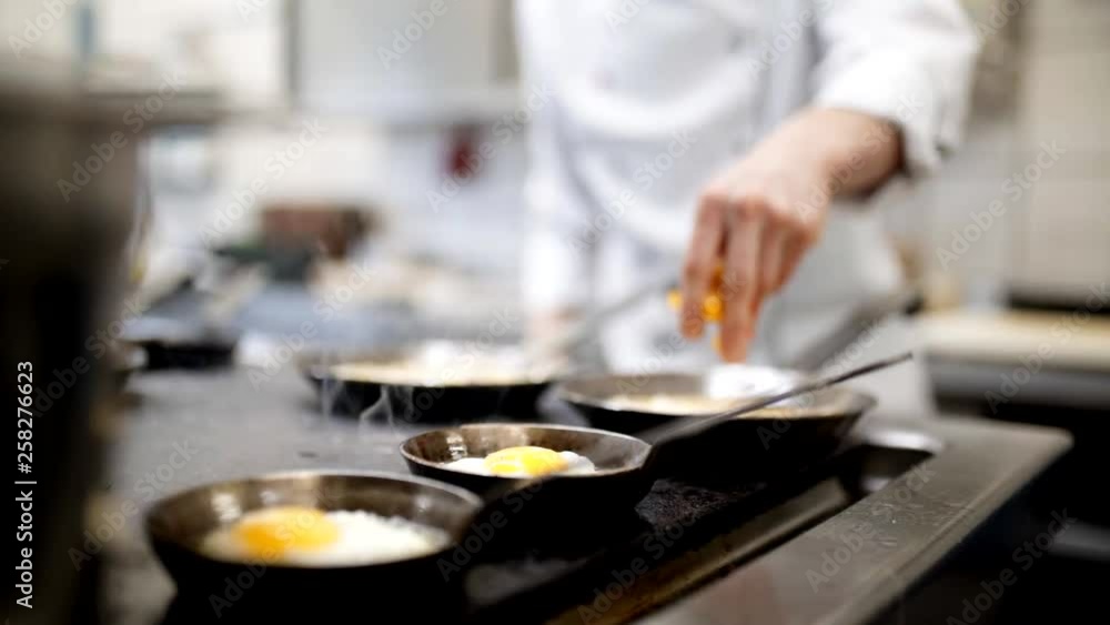 Chef puts eggs in the frying pan and fries delicious fried eggs for breakfast Chef puts eggs in the frying pan and fries delicious fried eggs for breakfast