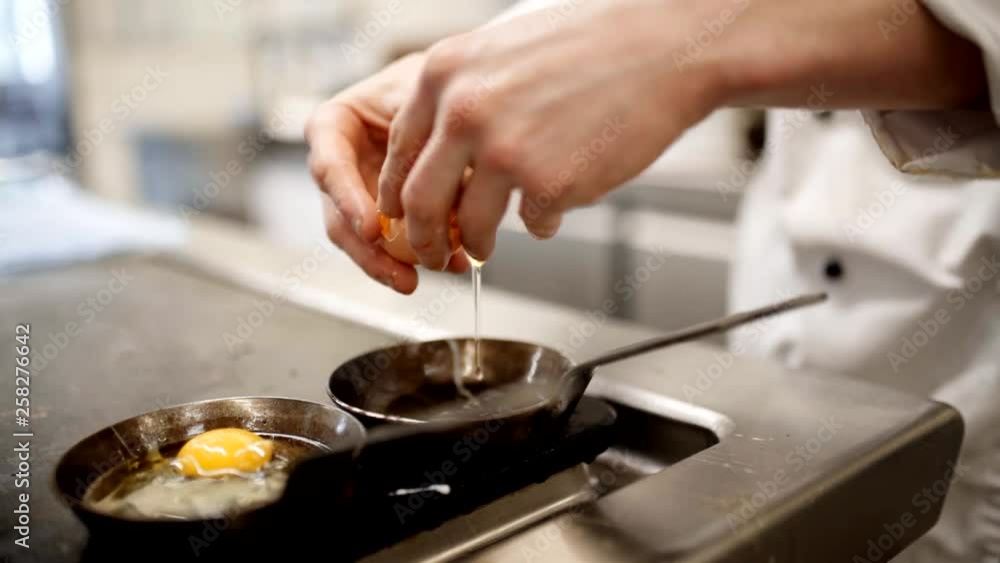 Chef puts eggs in the frying pan and fries delicious fried eggs for breakfast Chef puts eggs in the frying pan and fries delicious fried eggs for breakfast