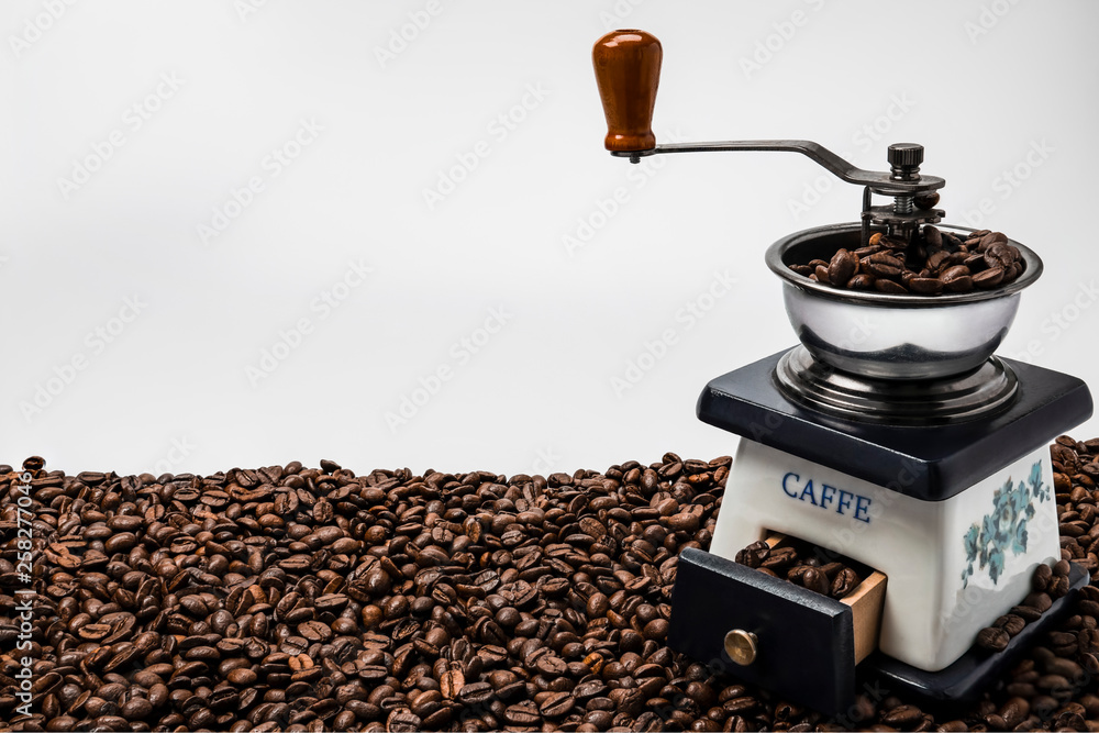 Coffee grinder and beans on white background