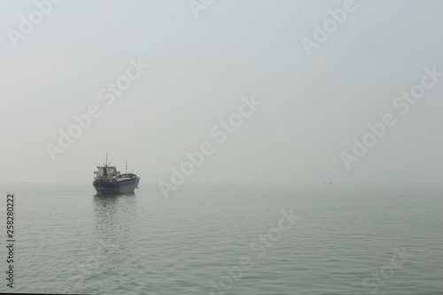 Merchant ship in the haze of Halong Bay