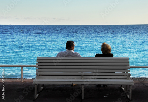 Couple sitting on a bench enjoying the view of azur blue Mediterranean. Promenade des Angles, Nice, France. Copy space © Turid Bjørnsen