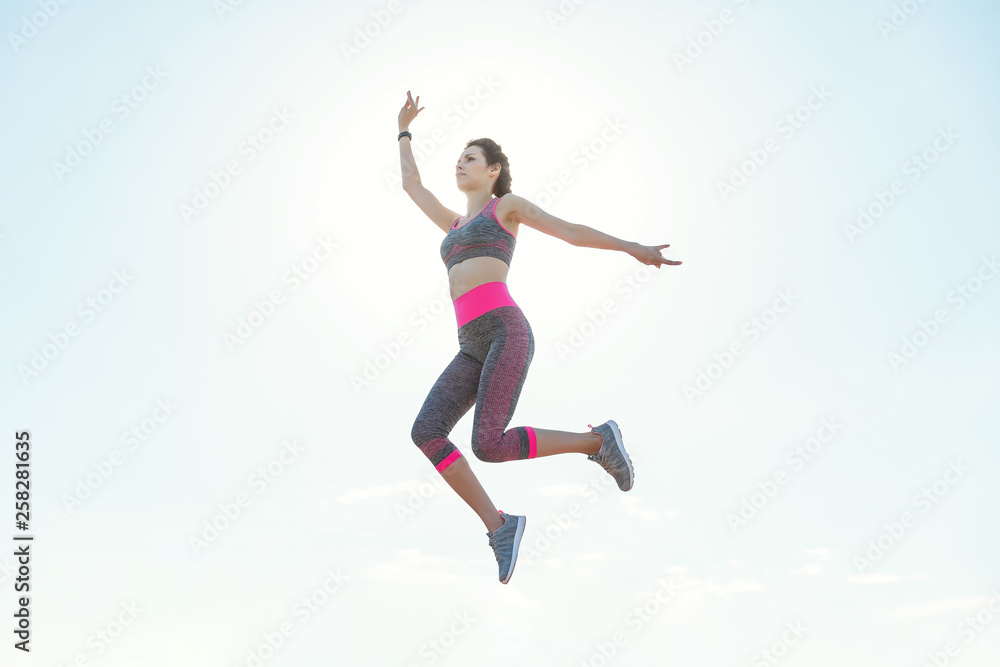 Sporty young girl in the morning on pier in jump, practicing yoga. Woman do gymnastics outdoors. Health and Yoga Concept. Female lifestyle meditation for fitness lifestyle the nature background