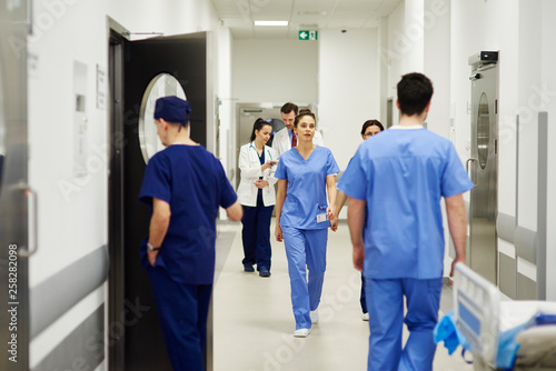 Doctors walking through corridor in hospital photo