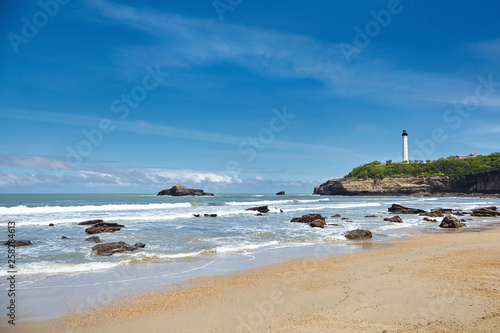 Sandy ocean beach and white lighthouse, located in Biarritz, France