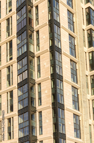 New high-rise building decorated with stone slabs with large Windows