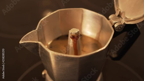 Brewing espresso coffee in moka pot - faster motion, closeup photo