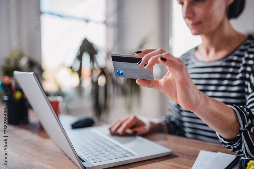Woman shopping online and using credit card Woman shopping online and using credit card