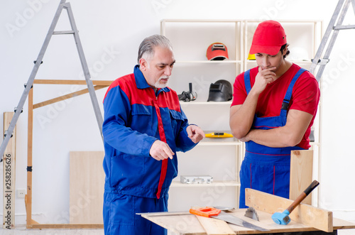 Two professional contractors laying flooring at home