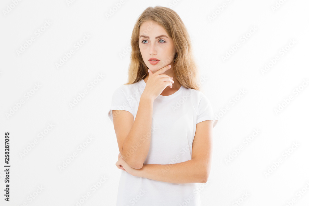 Thinking young blonde woman in blank template t shirt isolated on white background. Skin and hair care. Copy space and mock up Thinking young blonde woman in blank template t shirt isolated on white background. Skin and hair care. Copy space and mock up