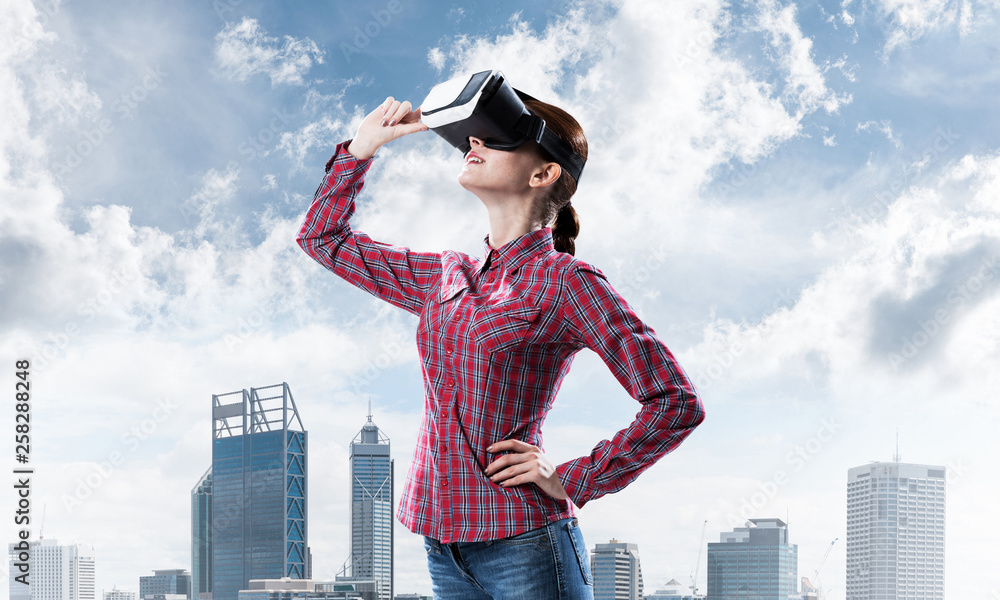 Girl in checked shirt wearing VR glasses experiencing another reality