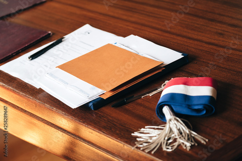 Documents placed on the table of a town hall, with a mayor's scarf and a soft light atmosphere photo