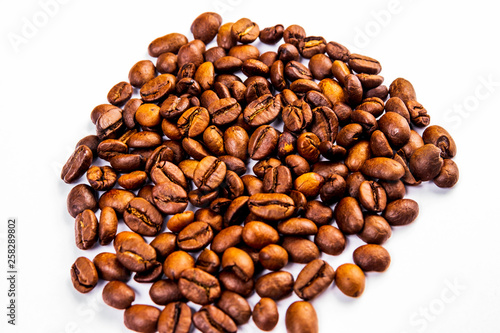 Roasted coffee beans in a glass cup isolated on a white background